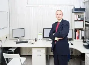 Confiant homme d'affaires à la recherche , posant devant un bureau bien équipé , représentant un propriétaire de petite entreprise