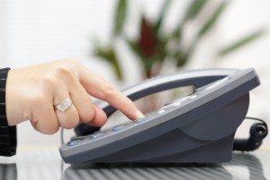 businesswoman is dialing on landline telephone