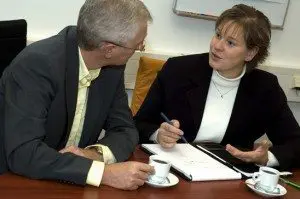 Two business people discussing. Focus is on the woman.
