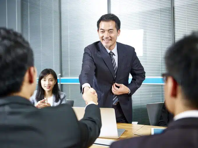 asian business men shaking hands before meeting