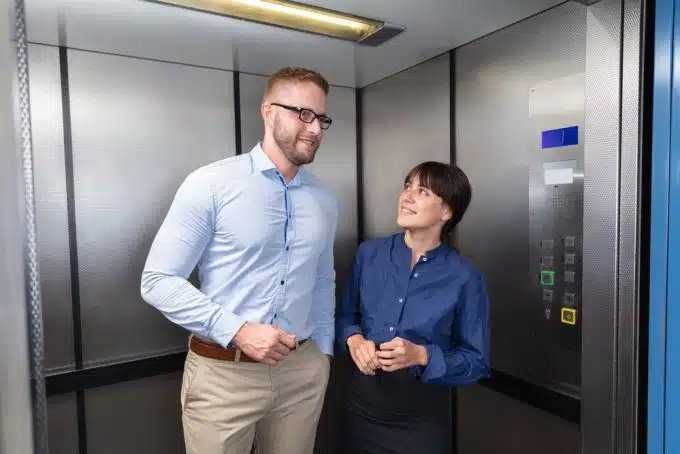 Businessman And Businesswoman Talking In Elevator