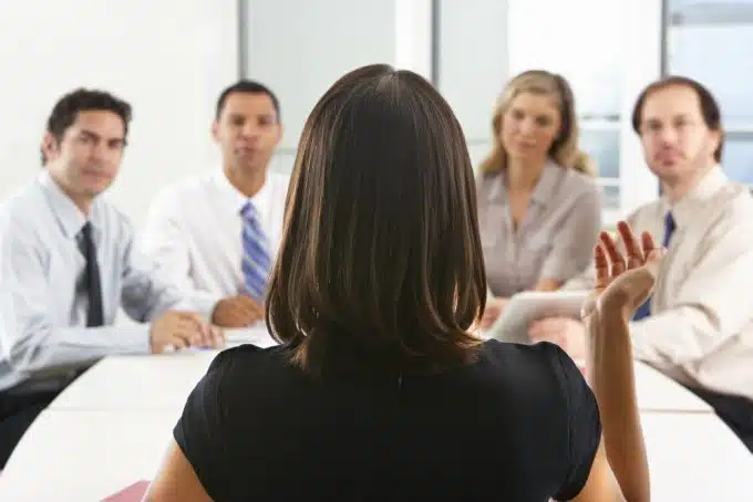 View From Behind As CEO Addresses Meeting In Boardroom