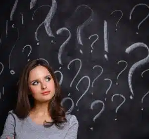 Young girl with question mark on a gray background