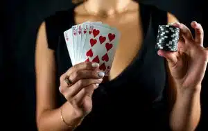 beautiful woman playing poker holding casino chips and dollars and enjoying winning.