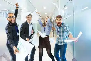 Group of joyful excited business people having fun in office