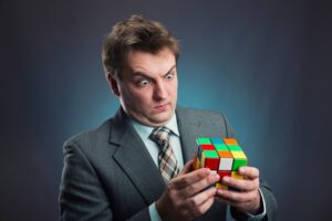 Businessman holding rubik cube in his hands Compliance Conundrum