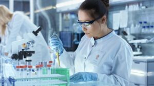 Female Research Scientist Uses Micropipette Filling Test Tubes i Drug Discovery and Development