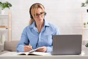 Workplace at home. Adult woman in glasses works remotely