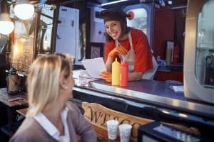 young satisfied female talking to customer who is leaving