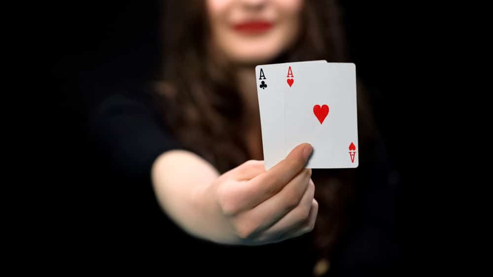 Female hand holding hearts and clubs aces, card pair, advantage, win chance Female hand holding hearts and clubs aces, card pair, advantage, win chance