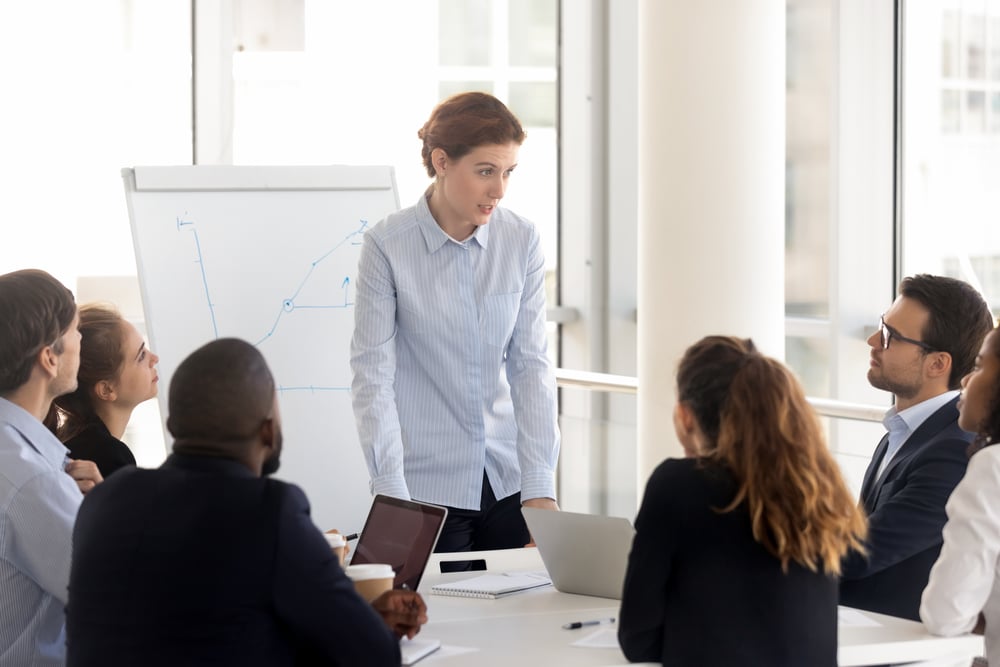 Serious female employee with flip chart at presentation. Serious female employee with flip chart at presentation.